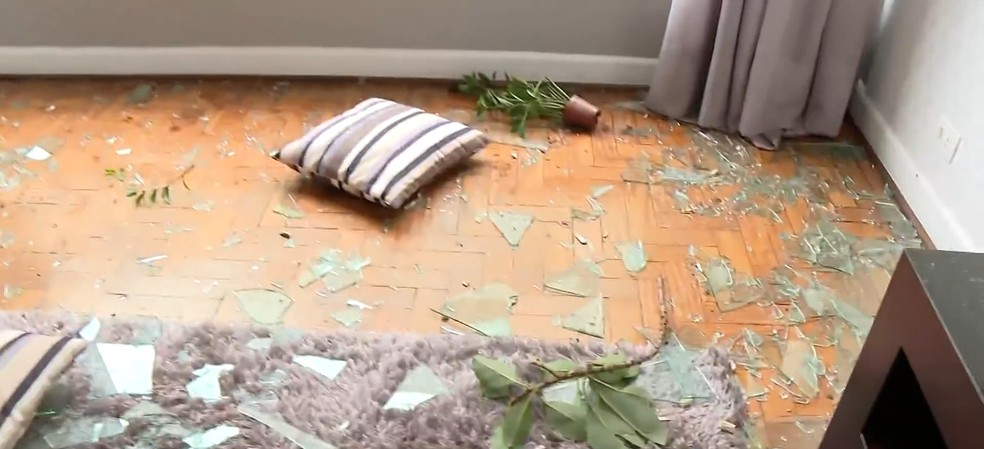Sala da casa com pedaços de vidro no chão. — Foto: Reprodução/ TV Globo