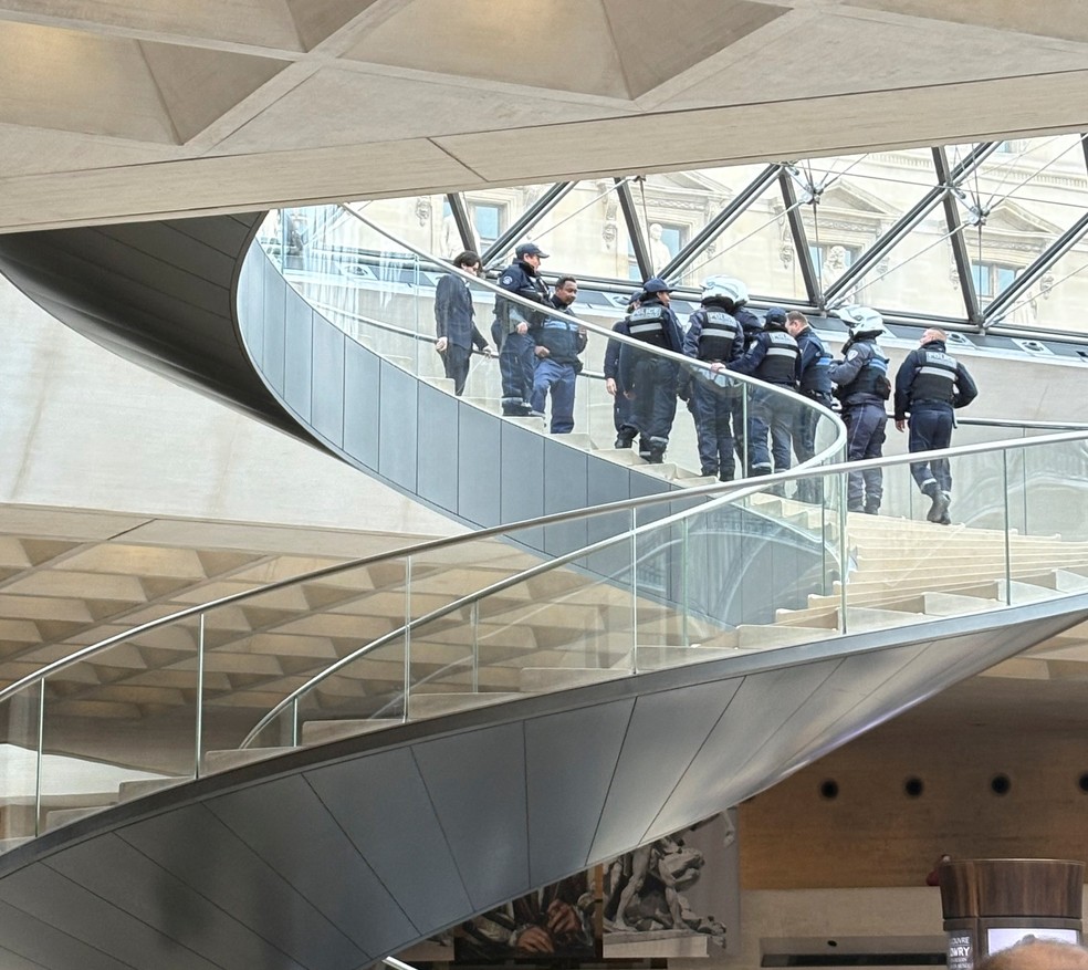 Policiais se reúnem na escadaria da Pirâmide do Louvre após roubo na manhã deste domingo (19) — Foto: Joan Carpenter Maccracken via Reuters