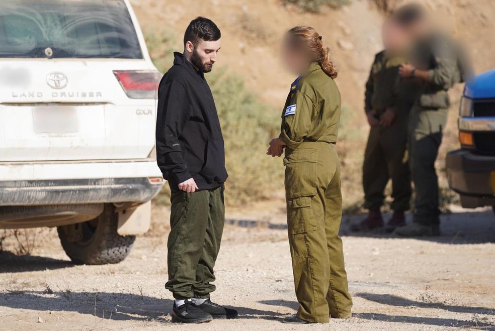 Refém libertado Matan Angrest com representantes das Forças de Defesa de Israel (IDF) — Foto: Divulgação/IDF