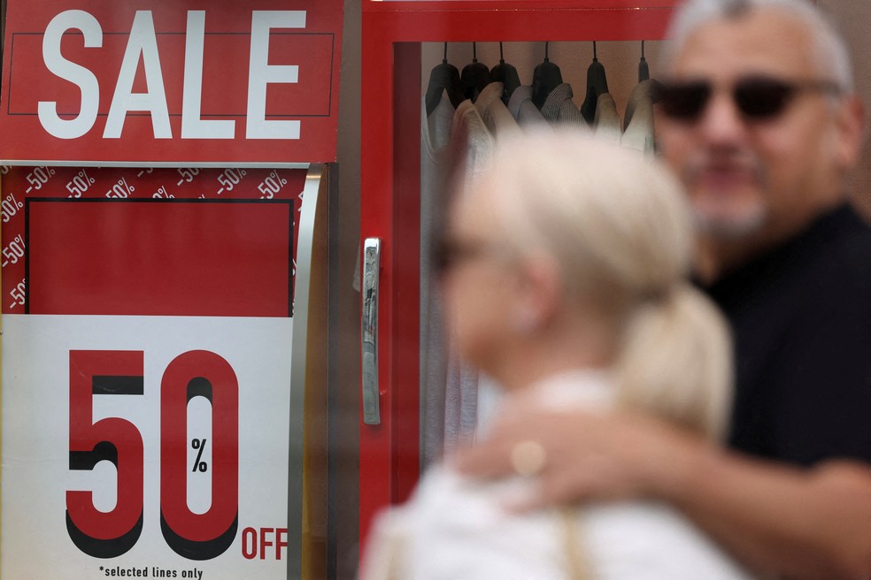 Consumidores passam por uma loja com promoção em Londres, na Inglaterra. — Foto: Reuters