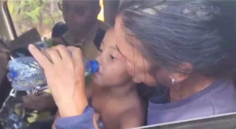 Menina Alice, que desapareceu em Jeceaba, bebe água dentro de carro logo após ser encontrada — Foto: Fabiano Villela/TV Globo