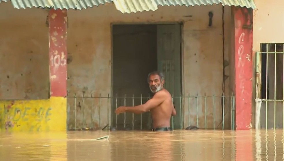 Morador da Muribeca, em Jaboatão dos Guararapes, em alagamento após fortes chuvas — Foto: Reprodução/TV Globo