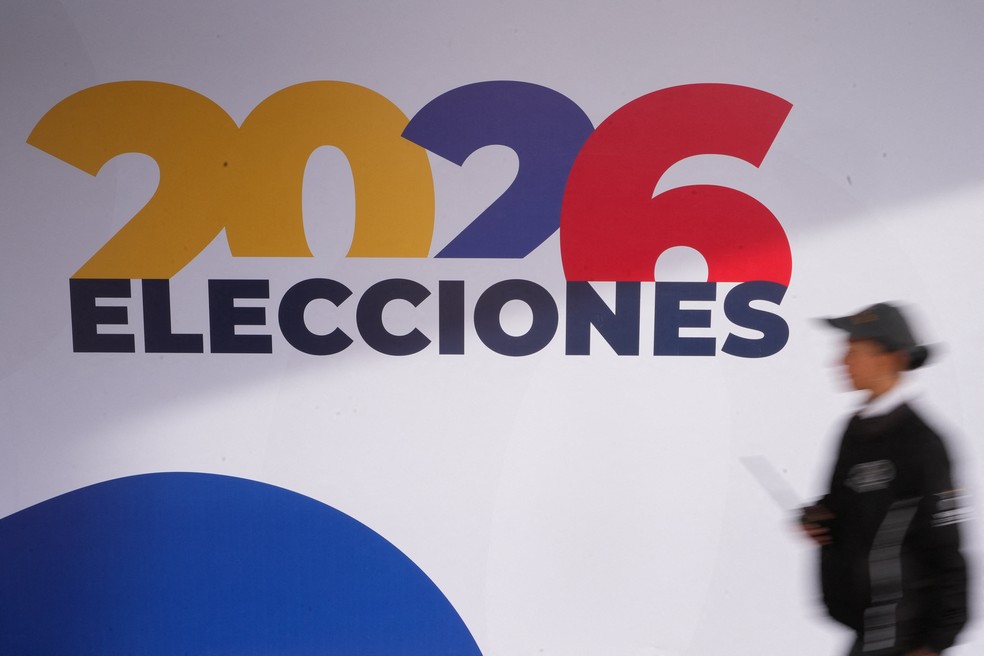 Uma pessoa passa por uma placa no centro de votação de Corferias, durante o primeiro turno da eleição presidencial, em Bogotá, Colômbia. — Foto: Enea Lebrun/Reuters