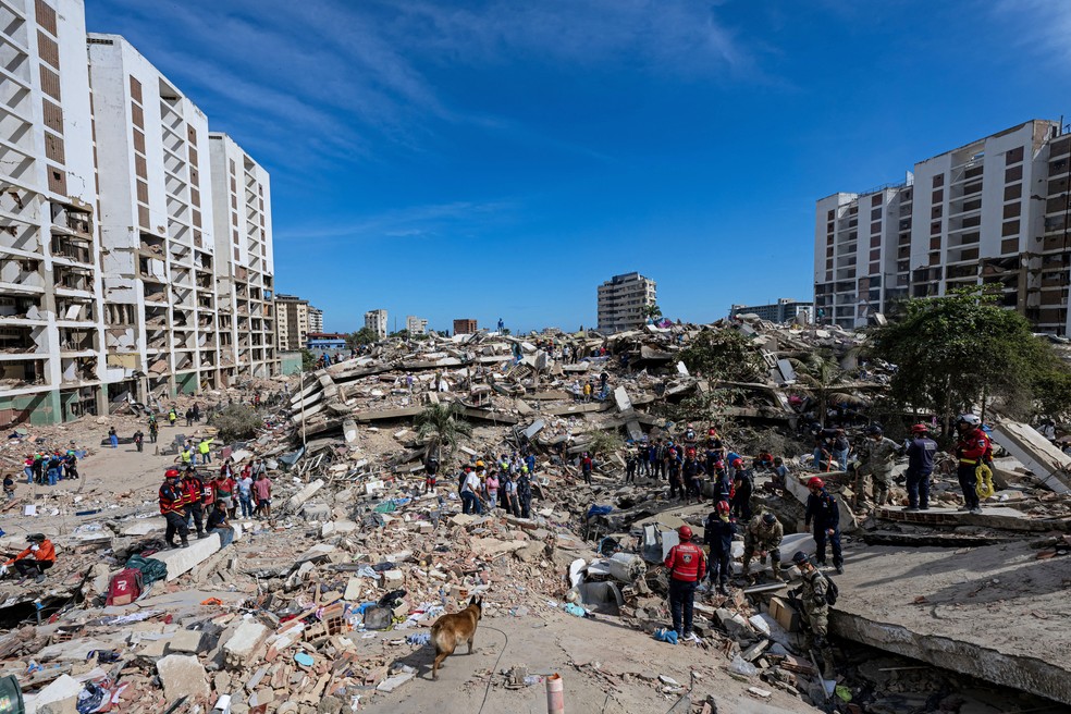 Equipes de resgate em busca de sobreviventes em meio a escombros de prédios em La Guaira, na Venezuela, em 28 de junho de 2026. — Foto: Miguel Medina/Pool/AFP