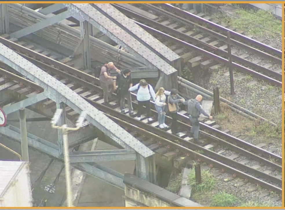 Policiais ajudam passageiros da Linha 12-Safira, na região da Avenida Celso Garcia, na Zona Leste de SP — Foto: Reprodução/TV Globo