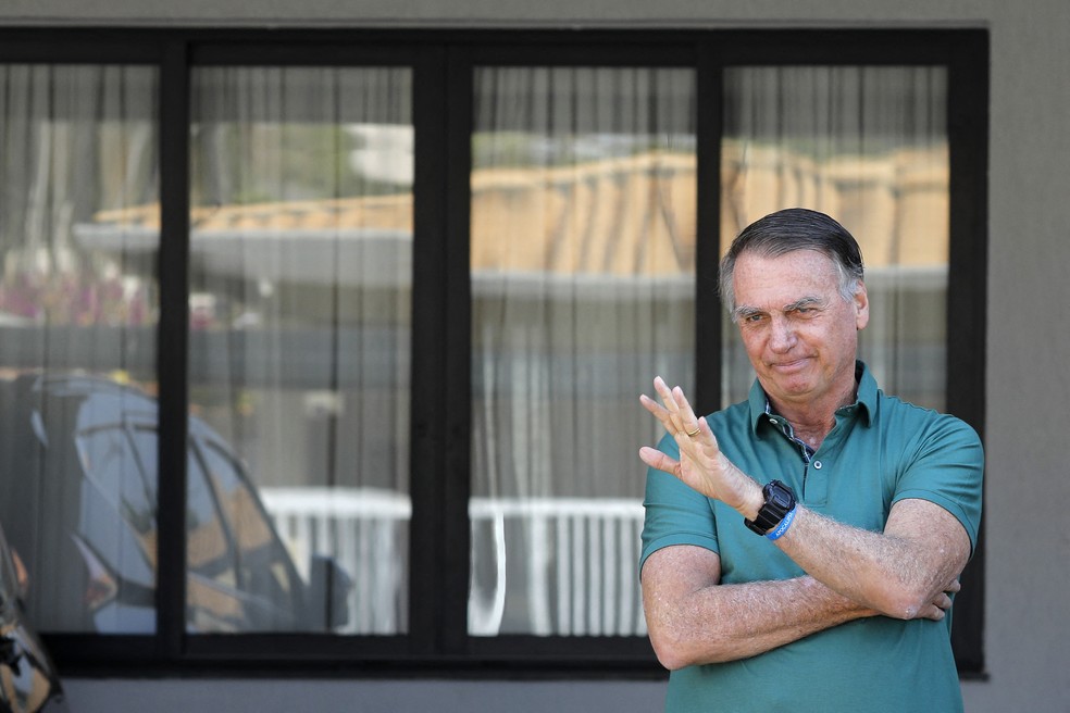 Jair Bolsonaro acena na garagem de casa, em Brasília — Foto: Sergio Lima/AFP
